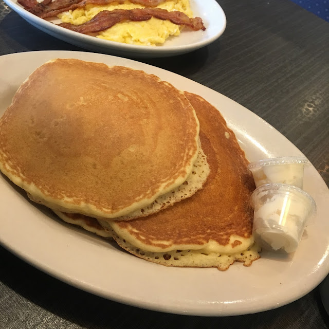 Golden Brown Pancakes Deluxe with Ham Bacon and Sausage Served with Butter and Maple Syrup